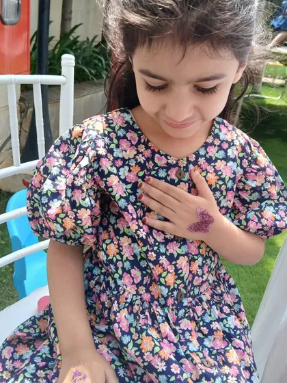 This little one is admiring her new purple butterfly glitter tattoo. It’s always a wonderful moment when a child sees their finished design for the first time.
