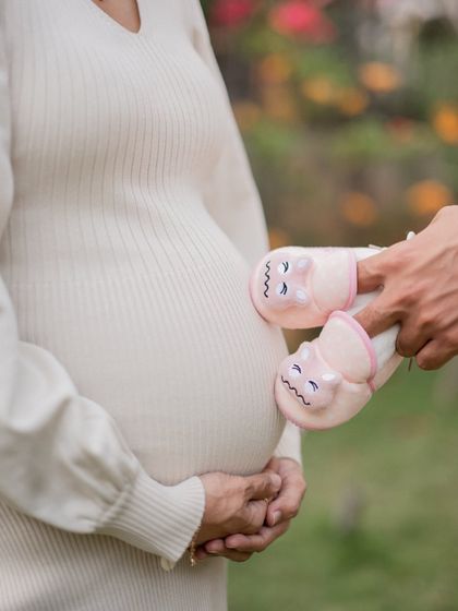A creative shot where the father's hands bring the baby's first shoes up to the bump. This is a lovely way to include your partner in the photos and symbolize the family you are becoming.