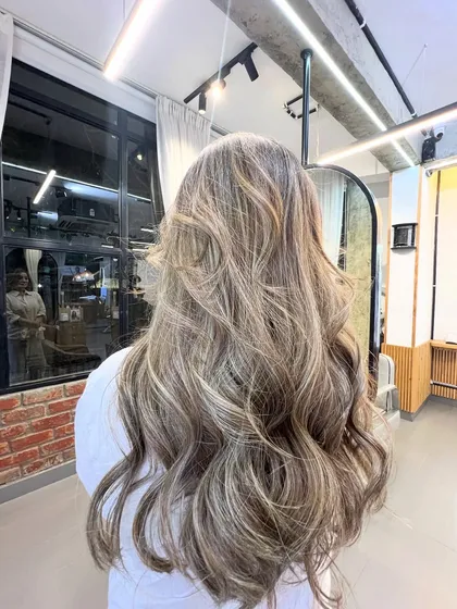 Another angle of the ash blonde balayage, showing the seamless transition from the darker roots to the light, ashy ends.