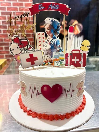 A special cake to celebrate a doctor, decorated with a heartbeat line, a first-aid kit, pills, and a thermometer.