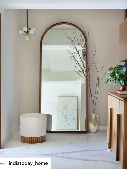 The elegant foyer of 'House on the Hill', featured in India Today Home. A large, arched mirror expands the space, while the simple wooden console and natural decor elements set a tone of organic luxury.