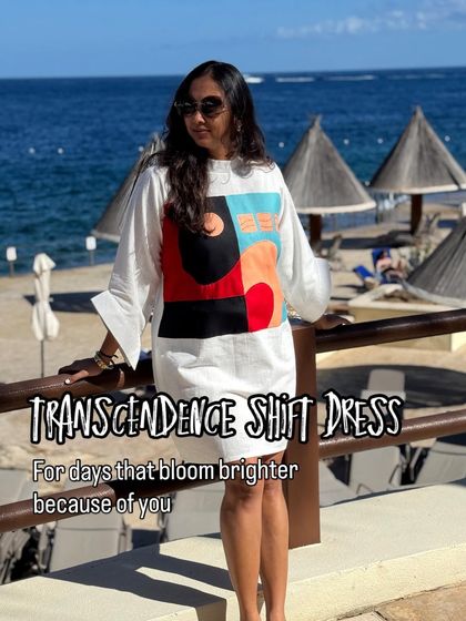 The Transcendence shift dress, for days that bloom brighter because of you. This vacation shot shows how the dress brings a pop of color and artistry to a beautiful beach setting.