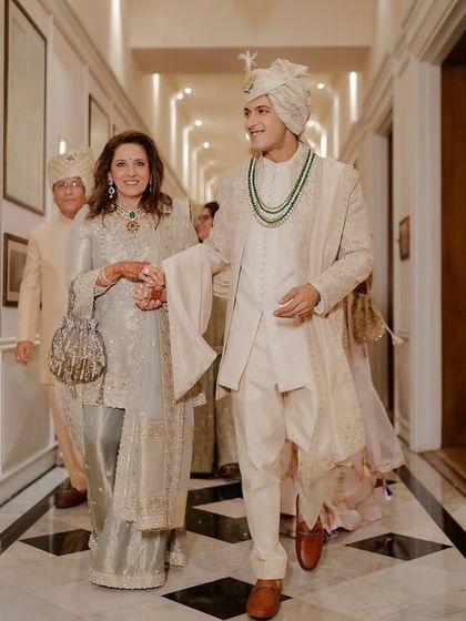The groom making his entrance, walking proudly with his mother.