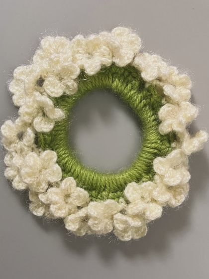 This hairtie is designed to look like a string of delicate white flowers, similar to a gajra but on a hair elastic.