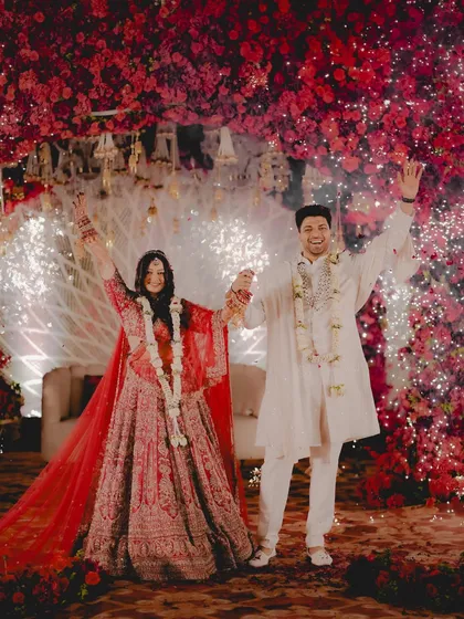 A triumphant moment for Priyanka and Ranjith under a sky of red blossoms and fireworks. This is the celebration after the sacred vows.