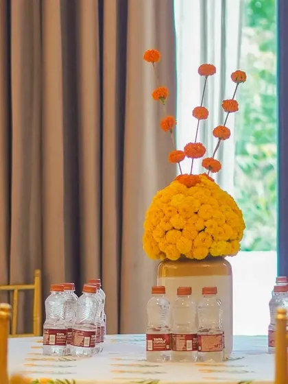 We love using ethnic centerpieces to add a traditional touch. This simple yet striking arrangement with a large marigold ball and floating single flowers is a perfect example of modern ethnic decor.
