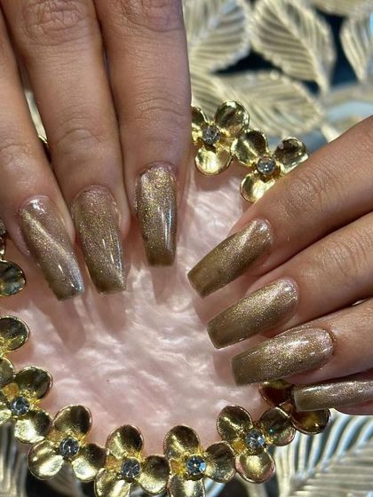 A gorgeous set of long, square-shaped nails with a golden-brown cat eye effect for a deep, magnetic look.