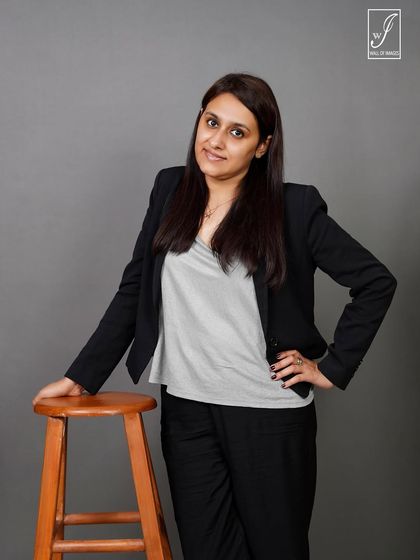 A standing pose next to a stool, offering a more dynamic and confident alternative to a standard headshot.
