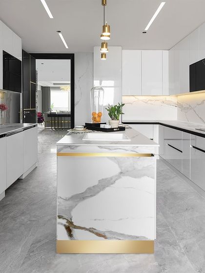 A throwback to one of our favorite kitchen designs. This modern, minimalist kitchen features high-gloss white cabinets, a marble-clad island with a gold accent band, and integrated appliances for a sleek and functional workspace.
