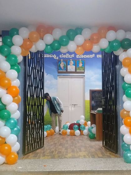 A balloon arch in saffron, white, and green at the entrance of a government office for a national holiday.
