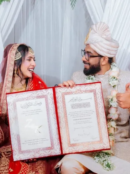 Pure happiness. The thumbs-up and bright smiles show the excitement of starting a new chapter together, with their custom Nikah certificate as a beautiful symbol of their union.