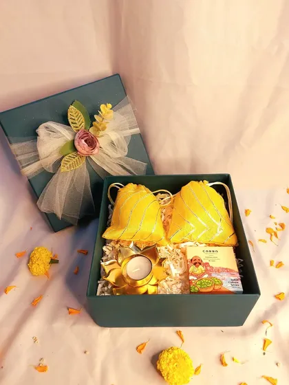 This simple yet elegant Diwali gift box is perfect for corporate or bulk orders. It contains two potlis of dry fruits, a decorative diya, and a box of chocolates, all beautifully presented.