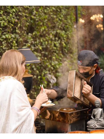 A guest enjoys a freshly steamed dim sum, served by our chef from a traditional bamboo basket. The steam rising from the station adds to the atmosphere and signals the freshness of the food.