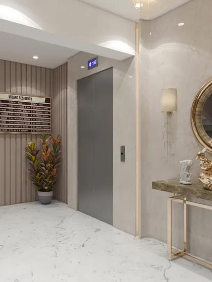 The entrance area of the Nerul lobby features a custom green marble console table and an ornate Ganesha statue, setting a tone of classic elegance. This space combines polished marble flooring and vertical wall fluting to welcome visitors with a refined aesthetic.