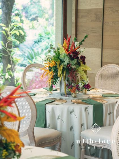 An elegant tablescape from the 'Garden of Gaia' event, with a tall floral centerpiece and custom-printed linens.