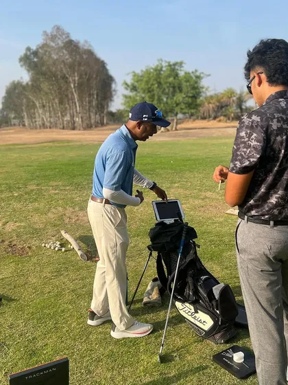 Using a tablet with a launch monitor, a coach discusses shot data with a player right on the driving range. This immediate feedback loop is a cornerstone of our coaching methodology.