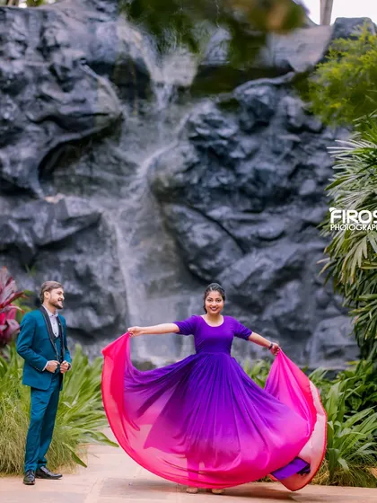 A playful, twirling pose in front of the waterfall, with the vibrant dress contrasting beautifully with the natural backdrop.