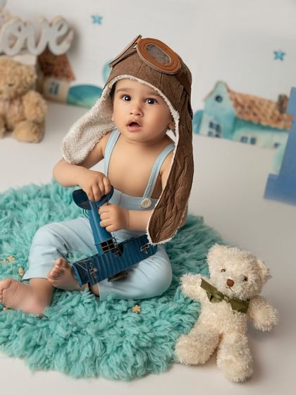 This little pilot is ready for takeoff in his aviator hat and vintage plane. Adventure-themed shoots are a wonderful way to capture a child's sense of wonder and exploration.