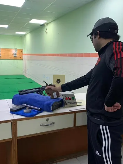 An adult shooter taking aim during a practice session. Success doesn't come to you, you go to it.
