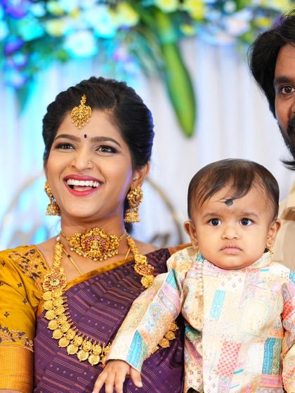 A real client looking joyous during her son's naming ceremony. She is wearing our classic kasumalai (coin necklace) set, which is perfect for family functions and celebrations.