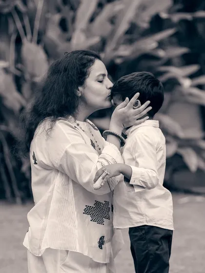 There is a unique tenderness in black and white photography. This candid shot of a mother's kiss captures a fleeting, heartfelt moment that transcends color.