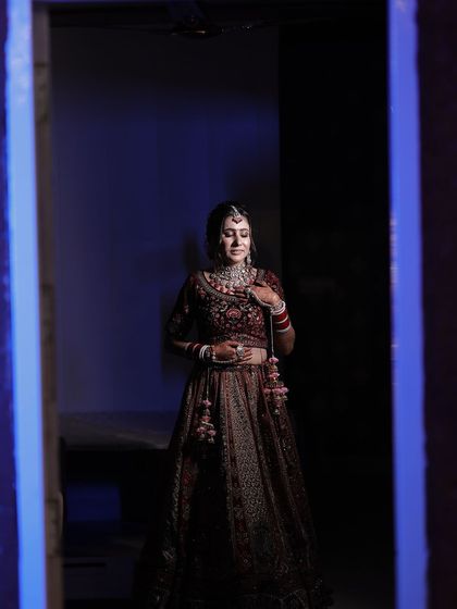 An artistic shot of the bride, showcasing her full lehenga and the elegant makeup that completes her look.