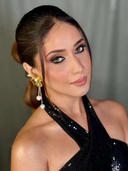 This portrait shot captures the full effect of the party makeup look. The skin is glowing, the eyes are the focus, and the hair is styled in a chic ponytail to complete the look.