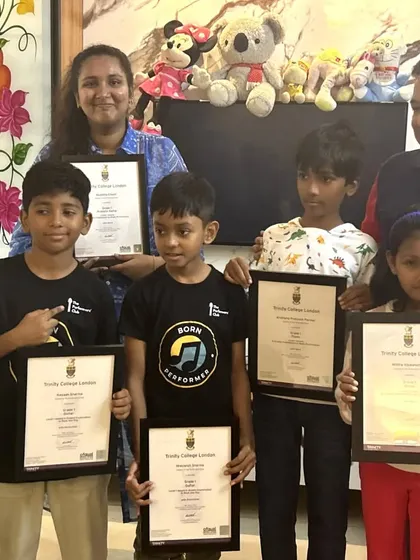A group of our certified young performers from Hyderabad holding up their Trinity College certificates. We are incredibly proud to guide these dedicated students on their path to becoming accomplished musicians.