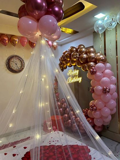 A view showing the connection between the balloon arch and the decorated bed in the romantic room surprise.
