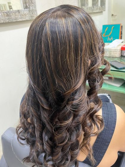 A side profile showcasing the detailed highlight work and voluminous curls. This style is glamorous and perfect for any special occasion.