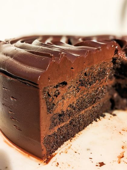 A cut view of our Belgian Dark Chocolate cake, revealing the dense, moist interior. This is the result of using the best ingredients and a recipe perfected over years.