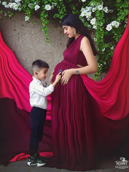 The little doctor is in. The big brother-to-be listens to his sibling's heartbeat with a toy stethoscope, a truly adorable and creative concept for a family maternity photo.