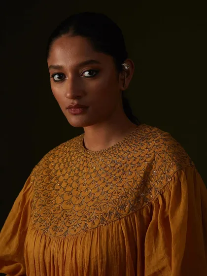 The rich texture of the embroidery on this mustard yellow top is the hero of this portrait.