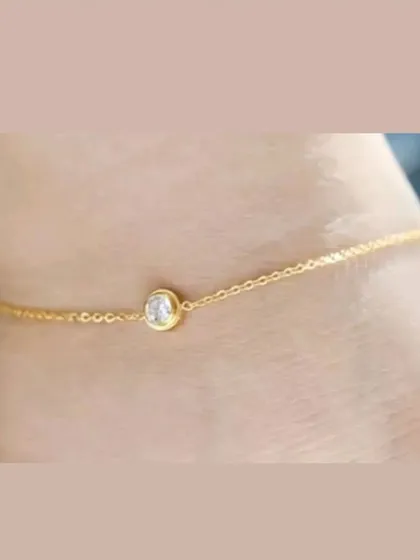 This simple and elegant anklet features a single bezel-set crystal on a delicate chain. It's a beautiful, subtle piece for any occasion.