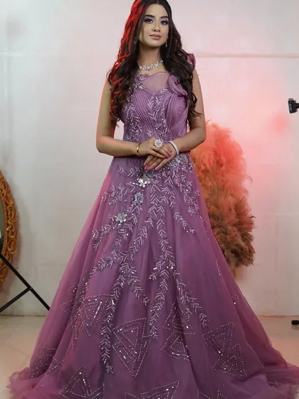 A full-length view of the stunning onion pink bridal gown. The flowing silhouette and detailed bodice are designed to make you feel like you're in a fairytale.