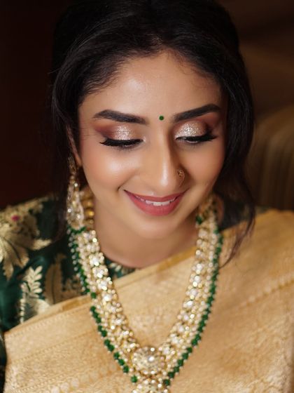 For Aditi's reception, we wanted her eyes to sparkle. I used a beautiful champagne glitter across the lids to complement the gold and green in her traditional saree, creating a look of pure elegance.