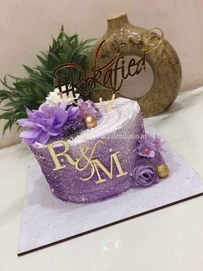 Our purple beauty. This bestselling single-tier design is perfect for a Roka ceremony, covered in purple glitter with a custom hashtag and initial toppers.