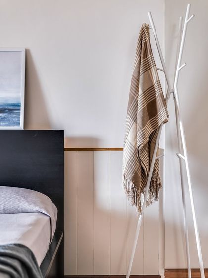 Even small details matter for storage. A simple, tree-like coat rack provides a convenient spot for guests to hang their belongings.