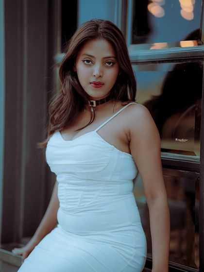 A striking portrait in a white dress, using the window grid and bokeh lights to create a beautiful, atmospheric background.