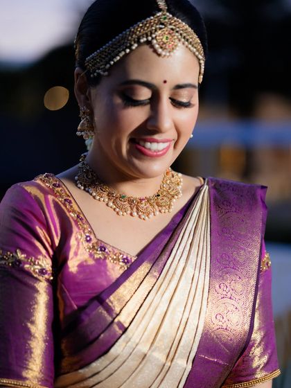 A close-up of her smiling, with the makeup looking soft and radiant, enhancing her natural glow.