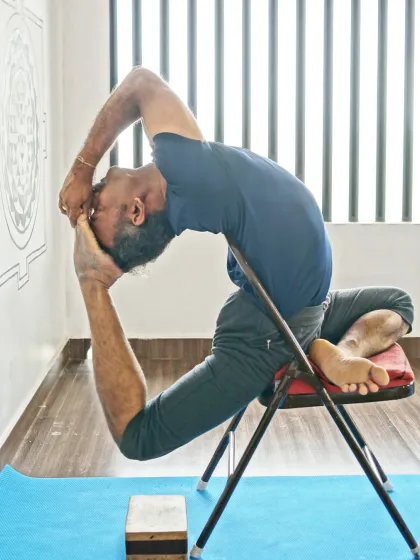 This is an advanced expression of Eka Pada Rajakapotasana, or King Pigeon Pose, using a chair for support. It shows how props can be used not just for accessibility, but to safely explore the full depth of a posture.