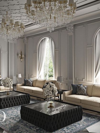 Expansive arched windows allow natural light to illuminate the classical columns and detailed ceiling. The arrangement of multiple sofas creates an ideal setting for large-scale entertaining in a grand, yet comfortable, environment.