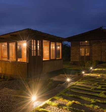 The cottages at Sakleshpur lit up at night, creating a warm and inviting glow against the dark landscape.