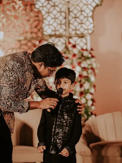 It’s not just about the couple; it’s about everyone. Here I am, giving the mic to a young star at a reception, making sure even the little ones feel included in the celebration.