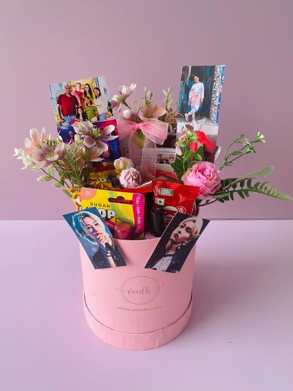 A birthday hamper for her in a round pink box. I've filled it with her favorite snacks, flowers, and personalized photos, including some of her favorite K-pop idols.