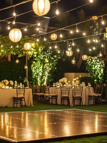An intimate outdoor reception setup. We used strings of lanterns and fairy lights to create a warm and magical canopy over the dance floor and dining area.