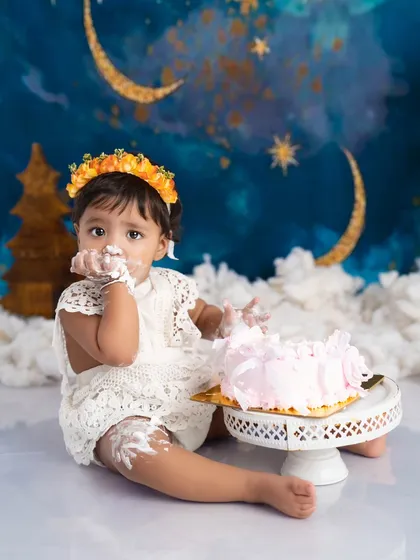 Getting every last bit of that delicious birthday cake. This is a candid moment from a fun and messy cake smash session, capturing the pure delight of a first birthday.