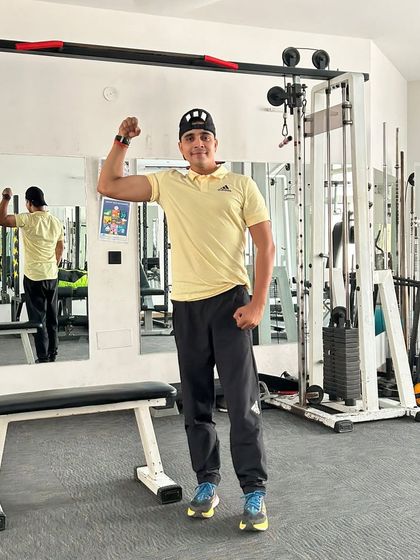 Bicep flex in a yellow shirt.