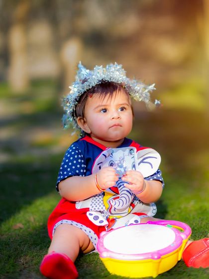 A sweet baby boy enjoying an outdoor photoshoot with his toys. The soft, natural light of the late afternoon creates a warm and gentle mood.