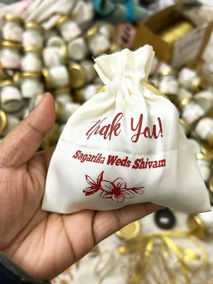 A close-up of our custom-printed potli bags. We can print your names, wedding date, and a thank you message directly onto the fabric for a personal touch.